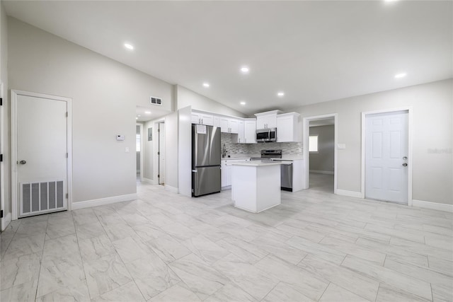 226 Palmyra Dr, Orlando, FL 32807 - kitchen with appliances with stainless steel finishes, vaulted ceiling, light countertops, a center island, and white cabinets