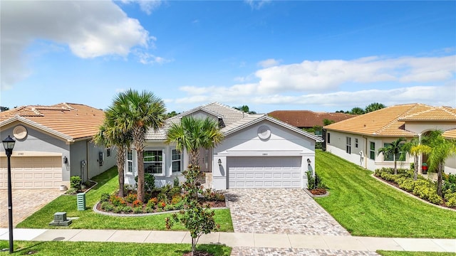 15503 Corona Del Mar Dr, Wimauma, FL 33598 - mediterranean / spanish-style home with a garage, a front yard, decorative driveway, stucco siding, and a tile roof