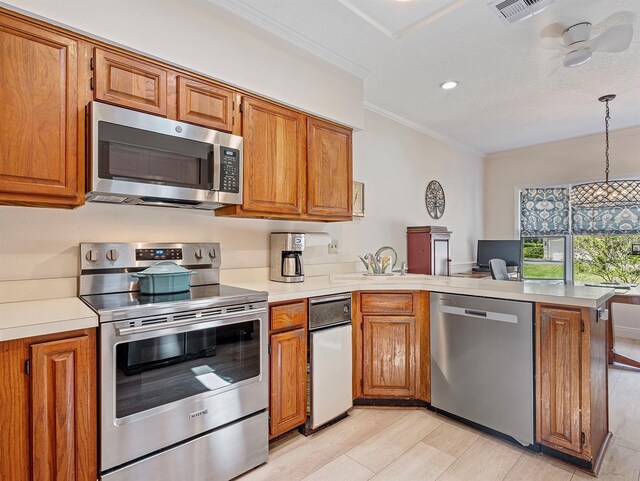 235 S Shadowbay Blvd, Longwood, FL 32779 - kitchen featuring appliances with stainless steel finishes, a peninsula, brown cabinets, crown molding, and recessed lighting