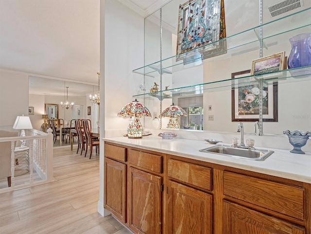 235 S Shadowbay Blvd, Longwood, FL 32779 - kitchen with ornamental molding, a chandelier, brown cabinets, light countertops, and light wood-style flooring