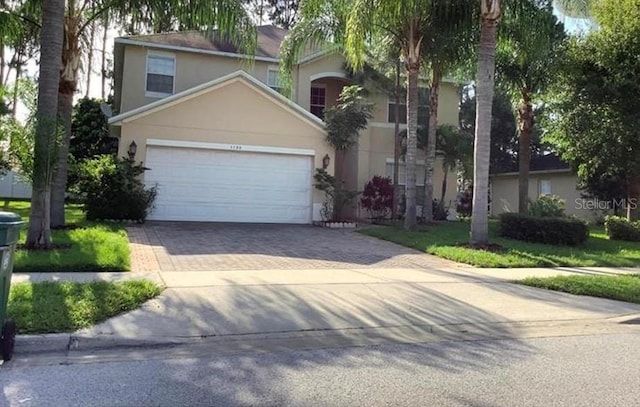 1130 Burland Cir, Winter Garden, FL 34787 - view of front of house with stucco siding, driveway, and a garage