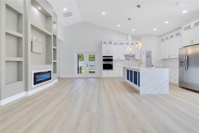 3507 W Jefferson St, Orlando, FL 32805 - unfurnished living room with french doors, recessed lighting, light wood-style floors, built in shelves, and high vaulted ceiling