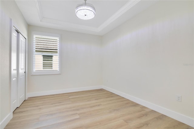 3507 W Jefferson St, Orlando, FL 32805 - spare room with a raised ceiling, light wood finished floors, a chandelier, and crown molding