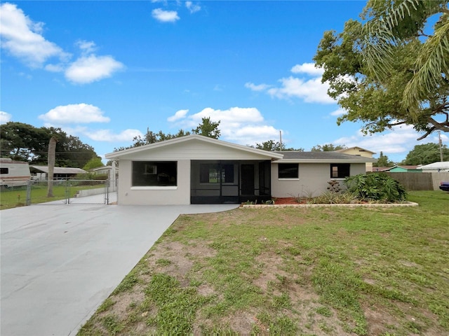2575 King Ave, Auburndale, FL 33823 - rear view of house featuring a gate, stucco siding, driveway, and a sunroom