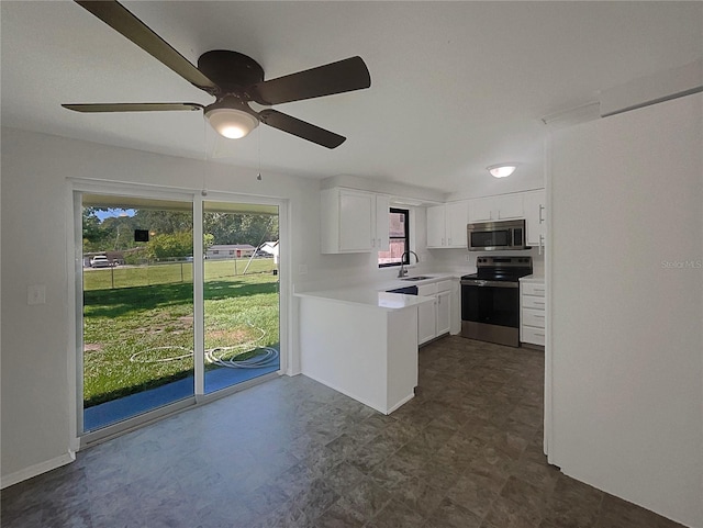2575 King Ave, Auburndale, FL 33823 - kitchen featuring appliances with stainless steel finishes, white cabinetry, light countertops, ceiling fan, and a peninsula