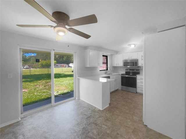 2575 King Ave, Auburndale, FL 33823 - kitchen featuring stainless steel appliances, white cabinets, light countertops, a ceiling fan, and light flooring