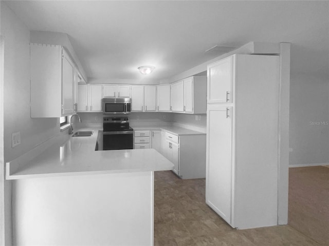 2575 King Ave, Auburndale, FL 33823 - kitchen featuring appliances with stainless steel finishes, a peninsula, light countertops, and white cabinets