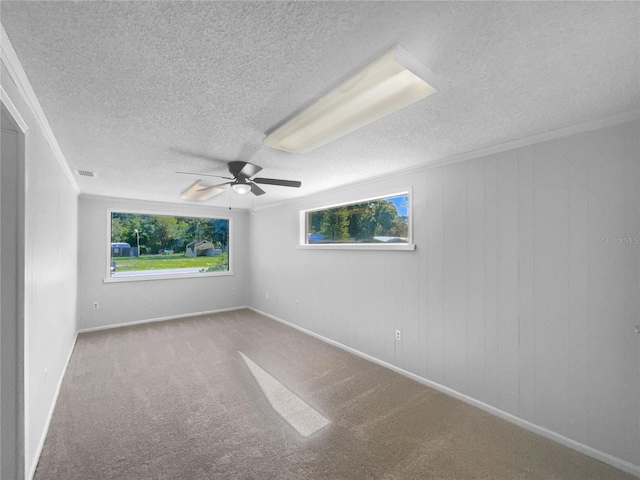 2575 King Ave, Auburndale, FL 33823 - spare room featuring a textured ceiling, healthy amount of natural light, a ceiling fan, carpet flooring, and ornamental molding