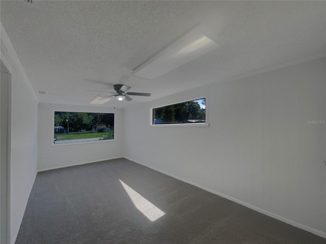 2575 King Ave, Auburndale, FL 33823 - empty room with a textured ceiling, plenty of natural light, dark colored carpet, and ceiling fan