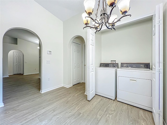 2353 Kingscrest Cir, Apopka, FL 32712 - laundry area with washing machine and dryer, light wood-style flooring, a chandelier, and arched walkways