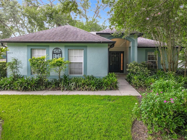 2353 Kingscrest Cir, Apopka, FL 32712 - view of front of home with stucco siding, a front lawn, and a shingled roof