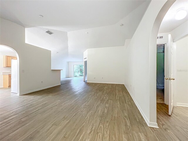2353 Kingscrest Cir, Apopka, FL 32712 - unfurnished living room featuring arched walkways, light wood-style flooring, and vaulted ceiling