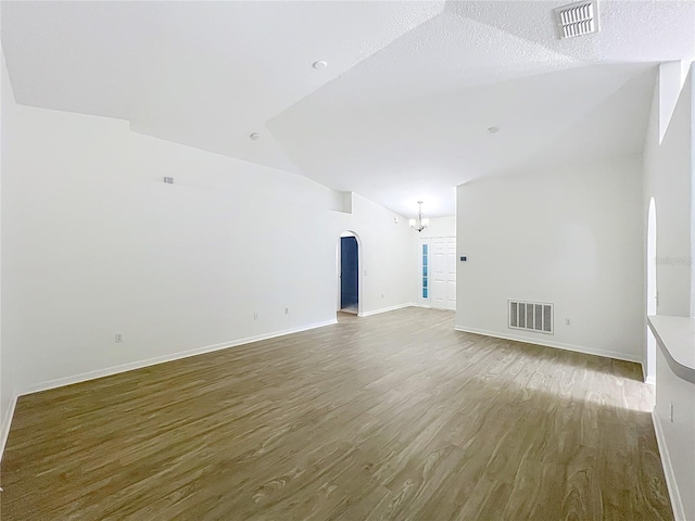 2353 Kingscrest Cir, Apopka, FL 32712 - spare room with vaulted ceiling, arched walkways, wood finished floors, and a chandelier