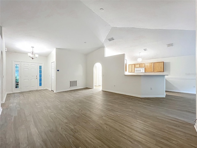 2353 Kingscrest Cir, Apopka, FL 32712 - unfurnished living room featuring a chandelier, dark wood-type flooring, vaulted ceiling, and arched walkways
