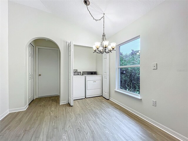 2353 Kingscrest Cir, Apopka, FL 32712 - washroom featuring washing machine and clothes dryer, light wood finished floors, arched walkways, and a chandelier