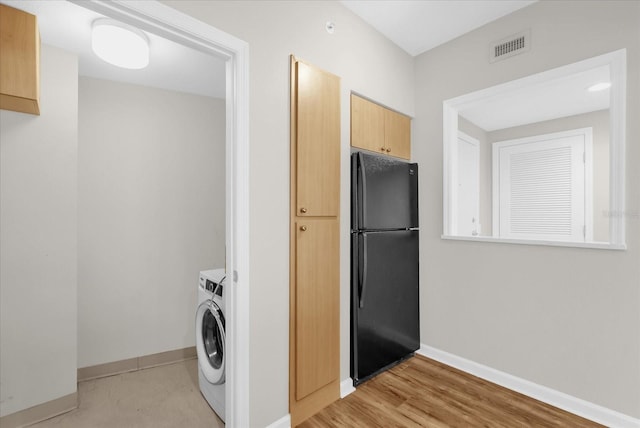 322 E Central Blvd Unit 614, Orlando, FL 32801 - washroom featuring washer / dryer and light wood-style flooring