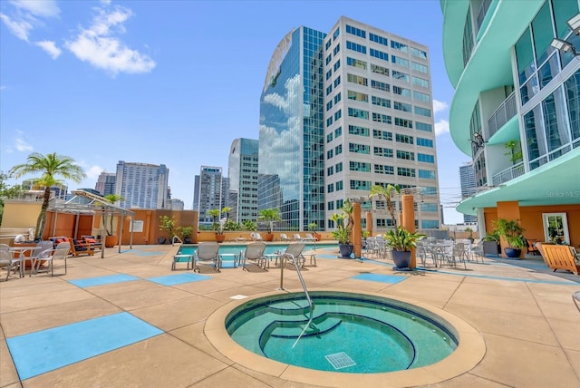 322 E Central Blvd Unit 614, Orlando, FL 32801 - community pool featuring a hot tub, a view of skyline, and a patio area