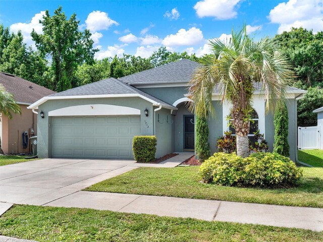 1712 Riveredge Rd, Oviedo, FL 32766 - view of front of home featuring an attached garage, stucco siding, concrete driveway, and roof with shingles