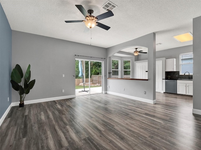 1712 Riveredge Rd, Oviedo, FL 32766 - unfurnished living room featuring a ceiling fan, dark wood finished floors, a textured ceiling, and arched walkways