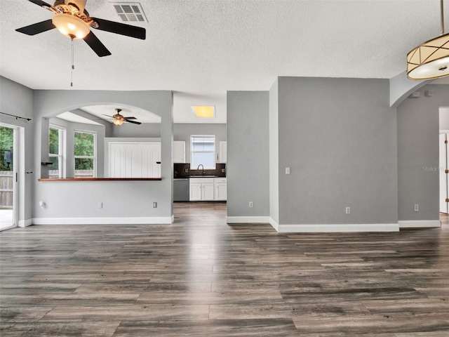 1712 Riveredge Rd, Oviedo, FL 32766 - unfurnished living room with ceiling fan, arched walkways, dark wood-type flooring, and a textured ceiling