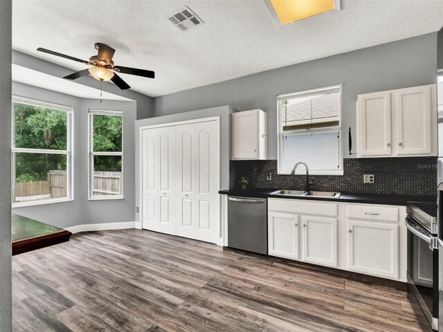 1712 Riveredge Rd, Oviedo, FL 32766 - kitchen with dishwasher, dark countertops, ceiling fan, range, and backsplash