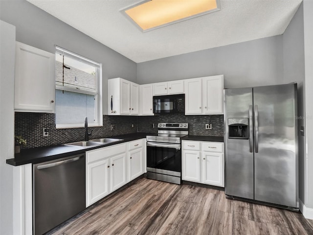 1712 Riveredge Rd, Oviedo, FL 32766 - kitchen with stainless steel appliances, dark countertops, and white cabinetry