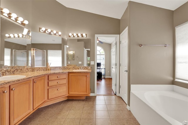 211 Tavestock Loop, Winter Springs, FL 32708 - full bathroom featuring healthy amount of natural light, double vanity, a shower stall, a bath, and vaulted ceiling