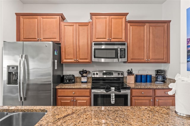 3193 Pequod Pl, Kissimmee, FL 34746 - kitchen featuring stainless steel appliances, light stone countertops, and brown cabinets