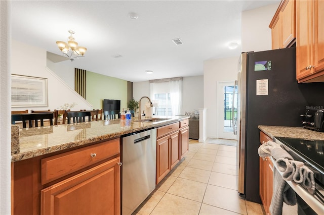 3193 Pequod Pl, Kissimmee, FL 34746 - kitchen with dishwasher, light tile patterned floors, a chandelier, range, and light stone counters