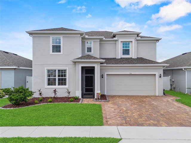 944 Benjamin Trl, Davenport, FL 33837 - view of front of home featuring decorative driveway, stucco siding, an attached garage, and a front lawn