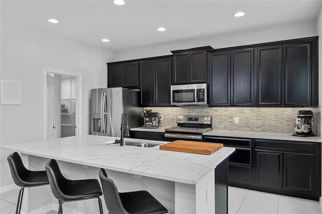 944 Benjamin Trl, Davenport, FL 33837 - kitchen with appliances with stainless steel finishes, dark cabinets, a center island with sink, tasteful backsplash, and recessed lighting