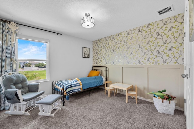 944 Benjamin Trl, Davenport, FL 33837 - carpeted bedroom with wallpapered walls, wainscoting, a textured ceiling, and a decorative wall