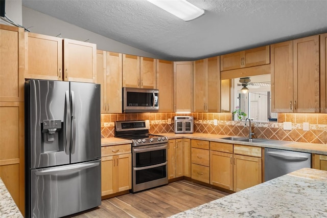 2921 Lake Tohopekaliga Blvd, Kissimmee, FL 34746 - kitchen featuring appliances with stainless steel finishes, light countertops, wood finished floors, a textured ceiling, and decorative backsplash
