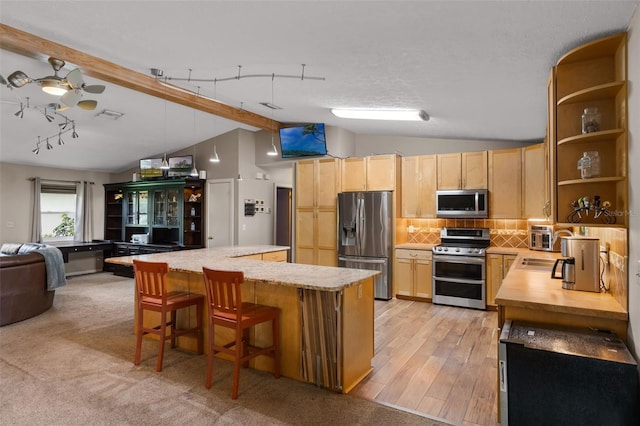 2921 Lake Tohopekaliga Blvd, Kissimmee, FL 34746 - kitchen with stainless steel appliances, light brown cabinets, open shelves, open floor plan, and a kitchen island