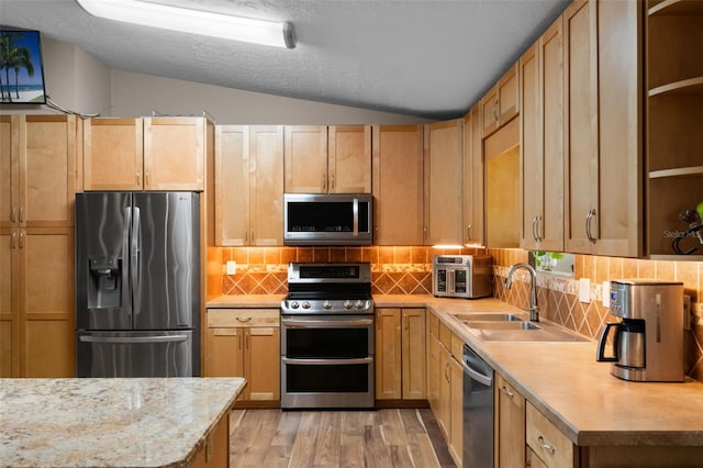 2921 Lake Tohopekaliga Blvd, Kissimmee, FL 34746 - kitchen featuring stainless steel appliances, light wood-style floors, decorative backsplash, lofted ceiling, and light stone countertops