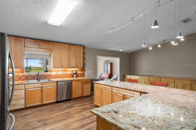2921 Lake Tohopekaliga Blvd, Kissimmee, FL 34746 - kitchen with appliances with stainless steel finishes, light wood-type flooring, backsplash, a textured ceiling, and light stone countertops