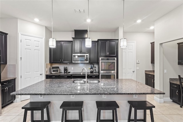 14536 Golden Harbor Ln, Winter Garden, FL 34787 - kitchen featuring stainless steel appliances, backsplash, a breakfast bar, light tile patterned floors, and recessed lighting