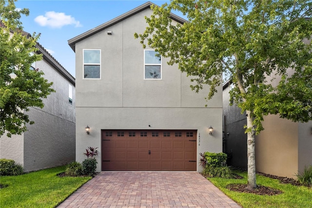 14536 Golden Harbor Ln, Winter Garden, FL 34787 - view of front of home featuring an attached garage, decorative driveway, and stucco siding