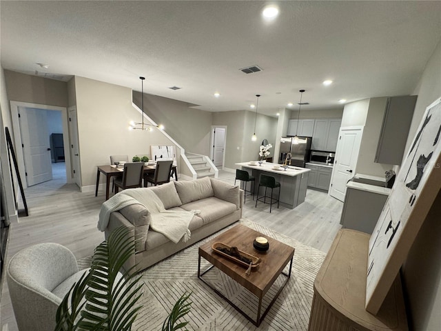 1526 Hempel Ave, Gotha, FL 34734 - living area with light wood-style floors, stairway, a chandelier, and recessed lighting