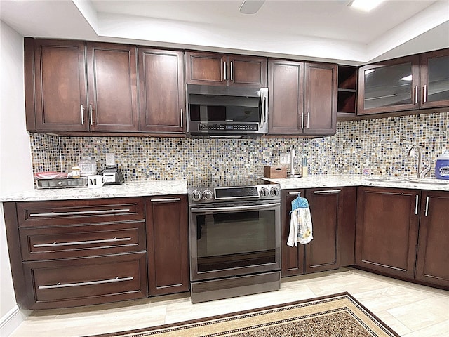 2400 Presidential Way Unit 1104, West Palm Beach, FL 33401 - kitchen featuring appliances with stainless steel finishes, dark brown cabinetry, and tasteful backsplash