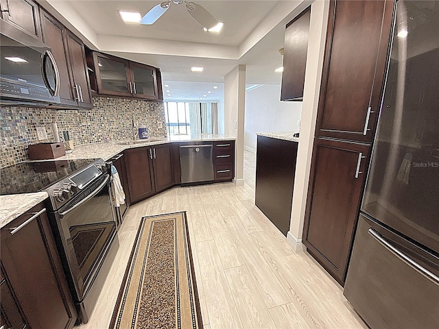 2400 Presidential Way Unit 1104, West Palm Beach, FL 33401 - kitchen with appliances with stainless steel finishes, ceiling fan, dark brown cabinetry, light wood-style floors, and decorative backsplash