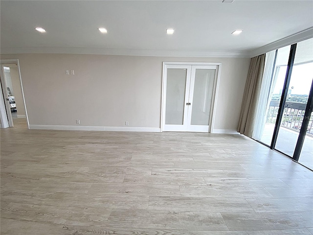 2400 Presidential Way Unit 1104, West Palm Beach, FL 33401 - empty room featuring crown molding, light wood finished floors, french doors, a wall of windows, and recessed lighting