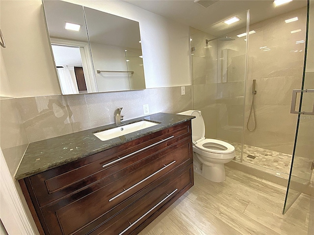 2400 Presidential Way Unit 1104, West Palm Beach, FL 33401 - bathroom featuring a stall shower, vanity, tile walls, tasteful backsplash, and wood finished floors