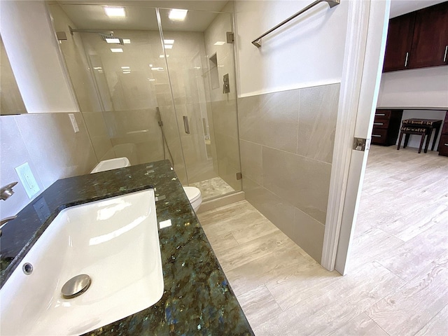 2400 Presidential Way Unit 1104, West Palm Beach, FL 33401 - bathroom featuring a stall shower, tile walls, vanity, and wood finished floors
