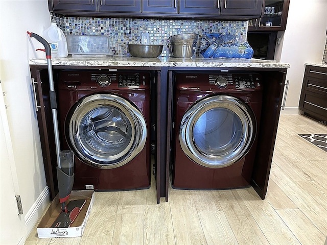 2400 Presidential Way Unit 1104, West Palm Beach, FL 33401 - washroom with washing machine and clothes dryer, light wood-style floors, and cabinet space