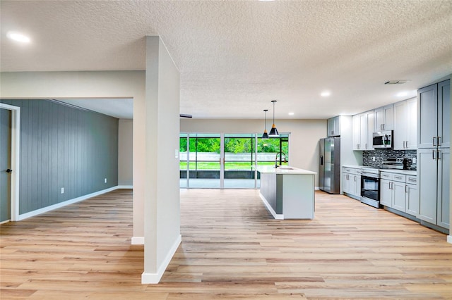 5938 Marlberry Dr, Orlando, FL 32819 - kitchen featuring stainless steel appliances, light wood finished floors, light countertops, decorative backsplash, and decorative light fixtures