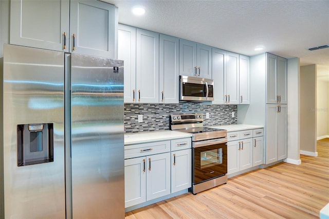 5938 Marlberry Dr, Orlando, FL 32819 - kitchen featuring appliances with stainless steel finishes, light wood-style floors, light countertops, backsplash, and recessed lighting