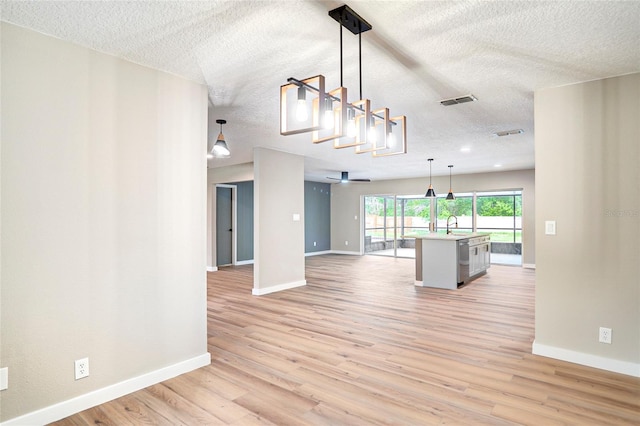 5938 Marlberry Dr, Orlando, FL 32819 - unfurnished living room with a textured ceiling and light wood-style flooring