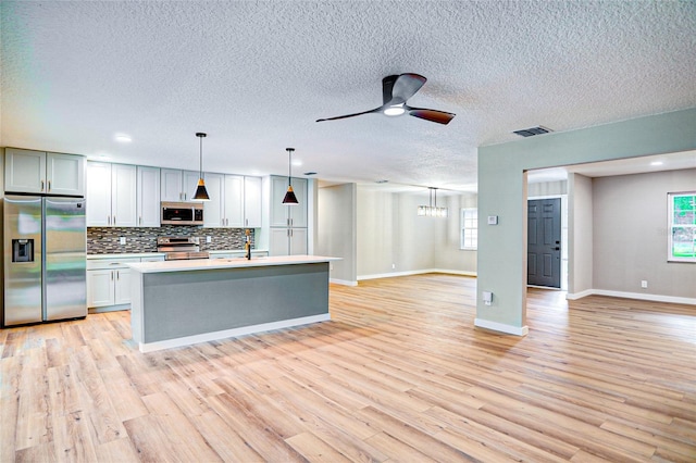 5938 Marlberry Dr, Orlando, FL 32819 - kitchen featuring appliances with stainless steel finishes, open floor plan, backsplash, light countertops, and plenty of natural light