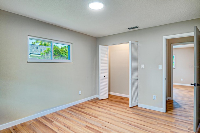5938 Marlberry Dr, Orlando, FL 32819 - unfurnished bedroom with light wood-style floors, a closet, and a textured ceiling